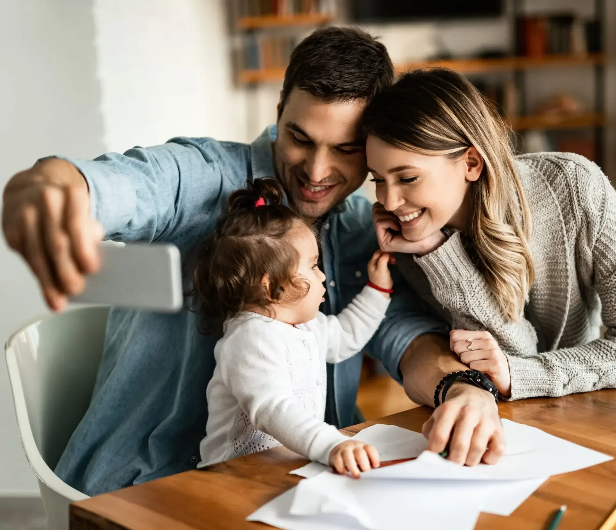 happy parents their small daughter taking selfie with mobile phone home min scaled 1 e1762090541765